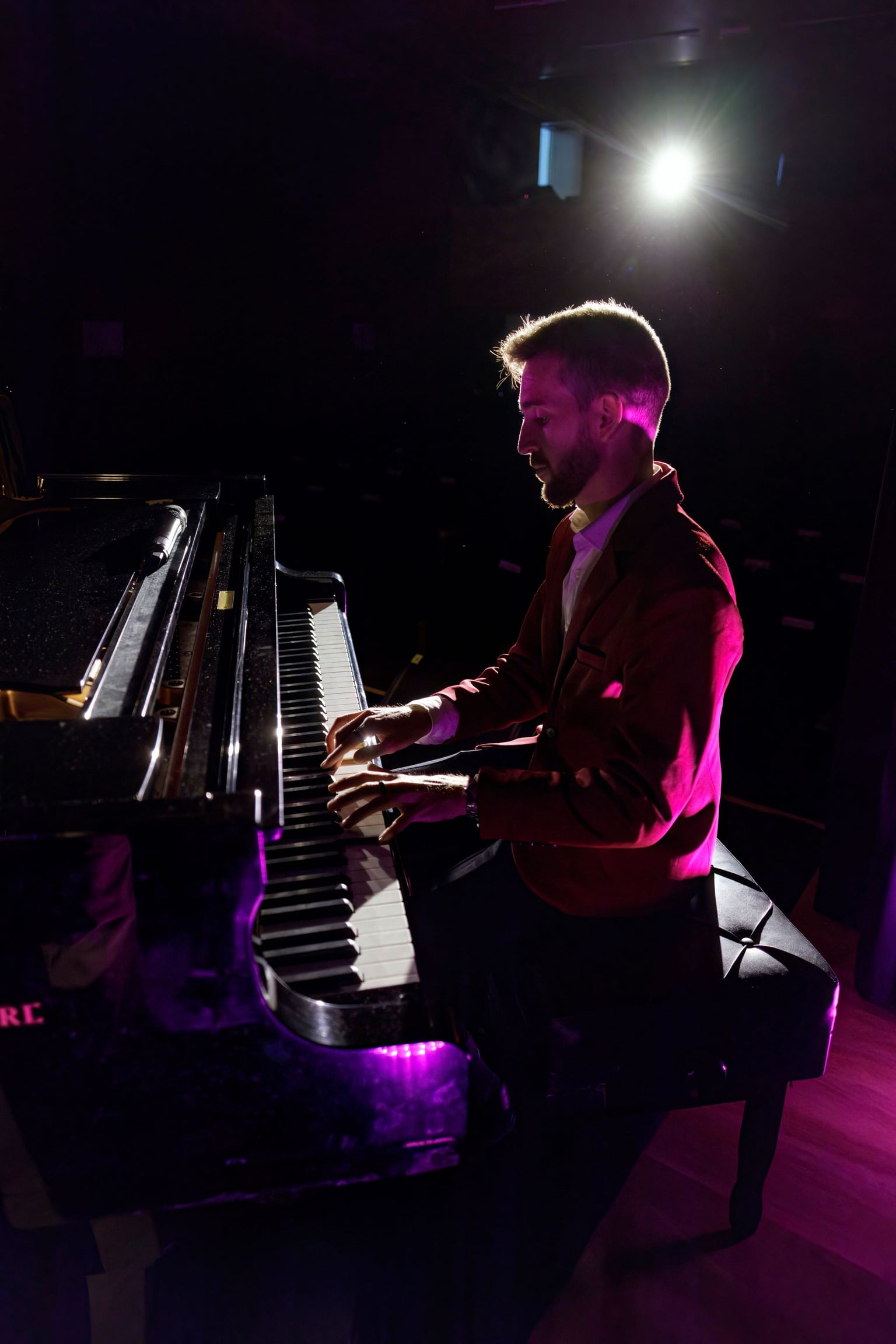 Josemi Castaño tocando el piano con iluminación magenta