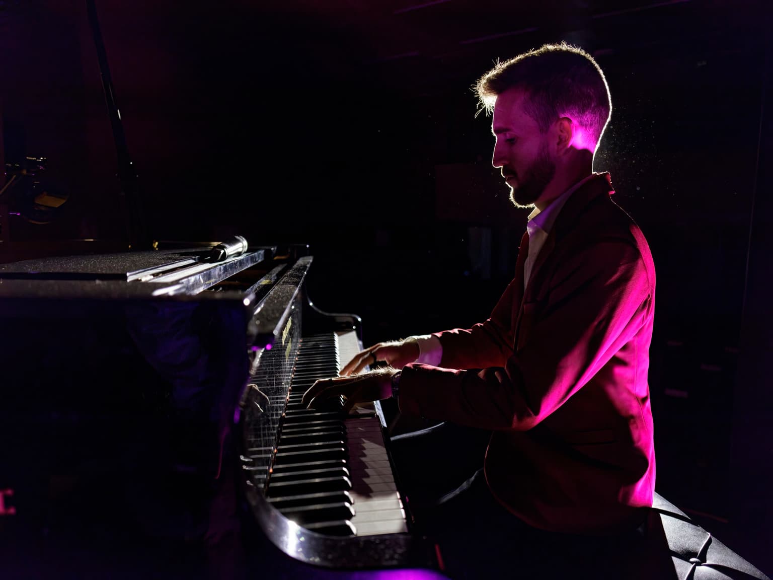 Josemi Castaño tocando el piano con iluminación dramática